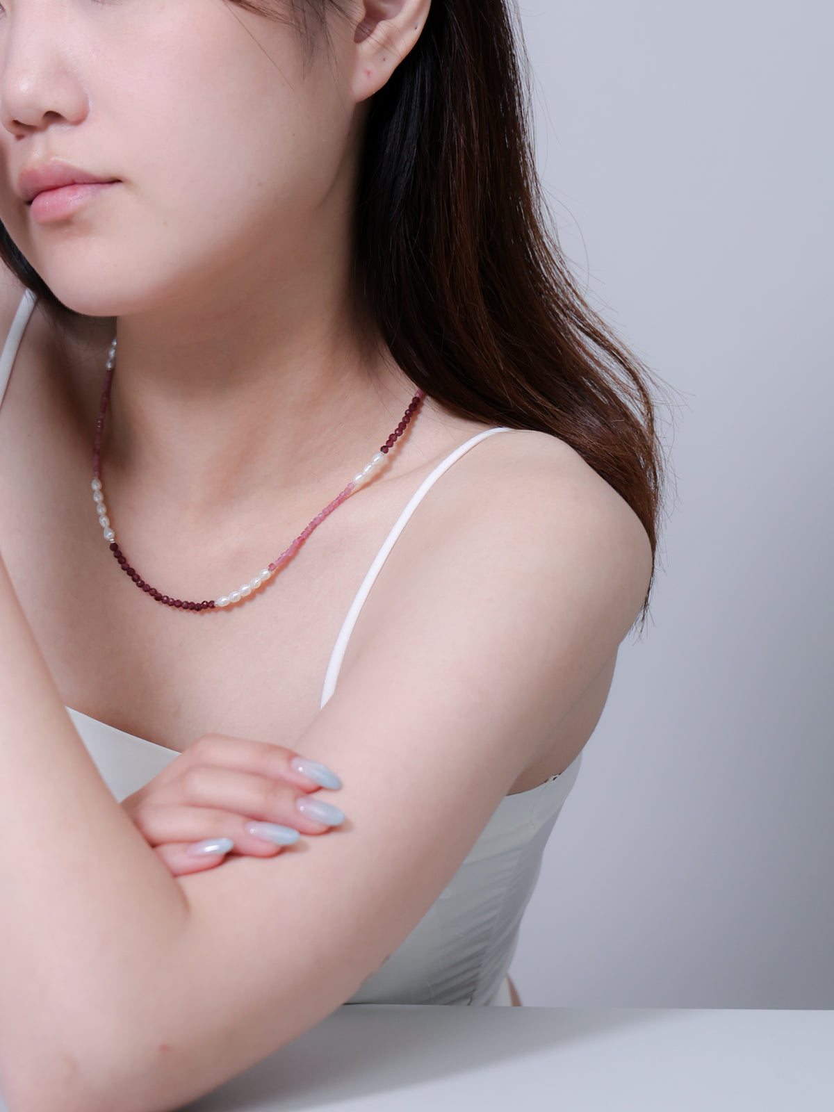 アンニュイな雰囲気のモデル着用写真。日常の装いにドラマティックな彩りを添える、存在感のあるネックレス。