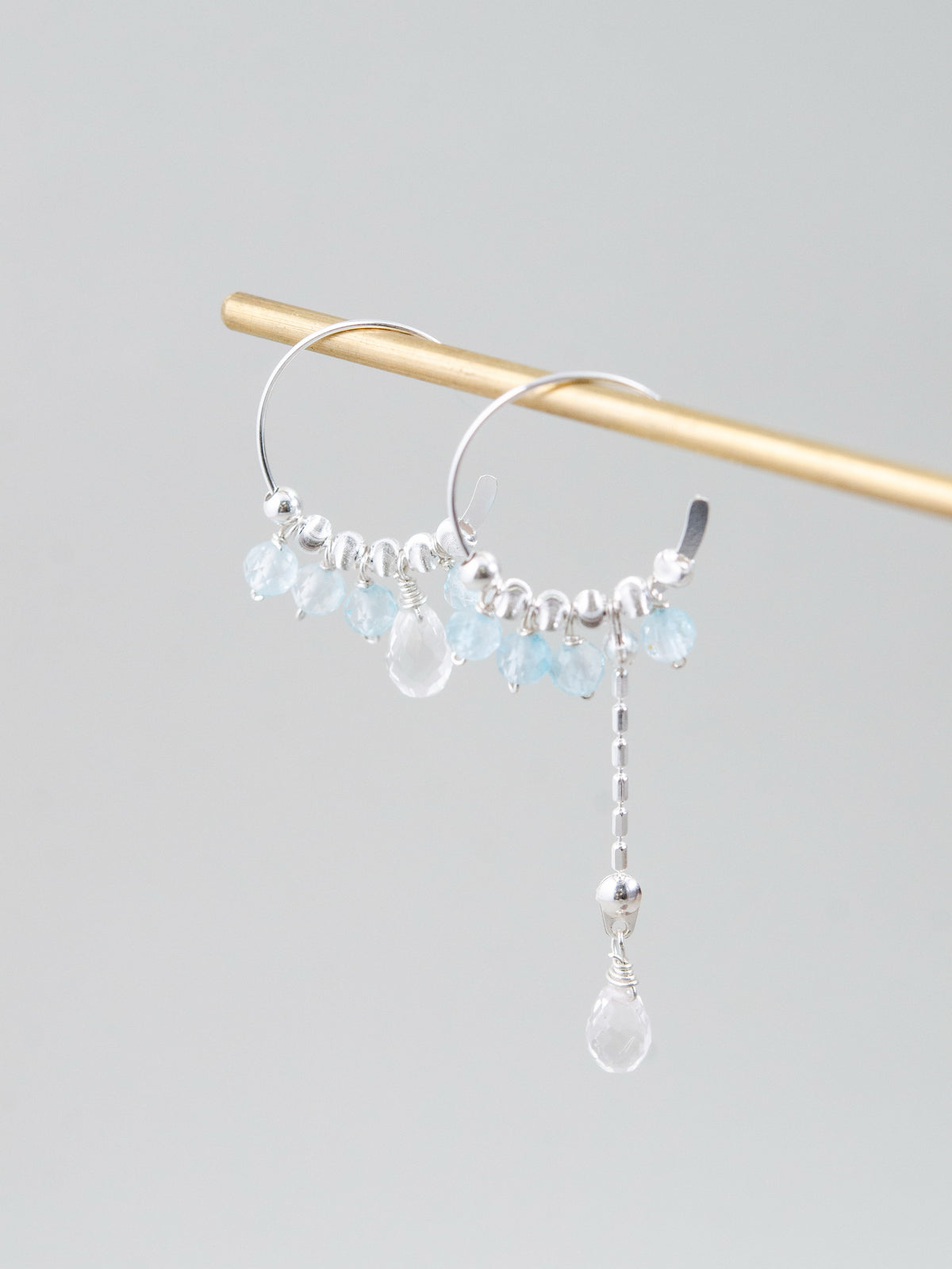 吊るし画像の別アングル。光を受けてキラキラと輝く「氷の戯れ」をイメージした、透明な雫型のクリスタル詳細。
