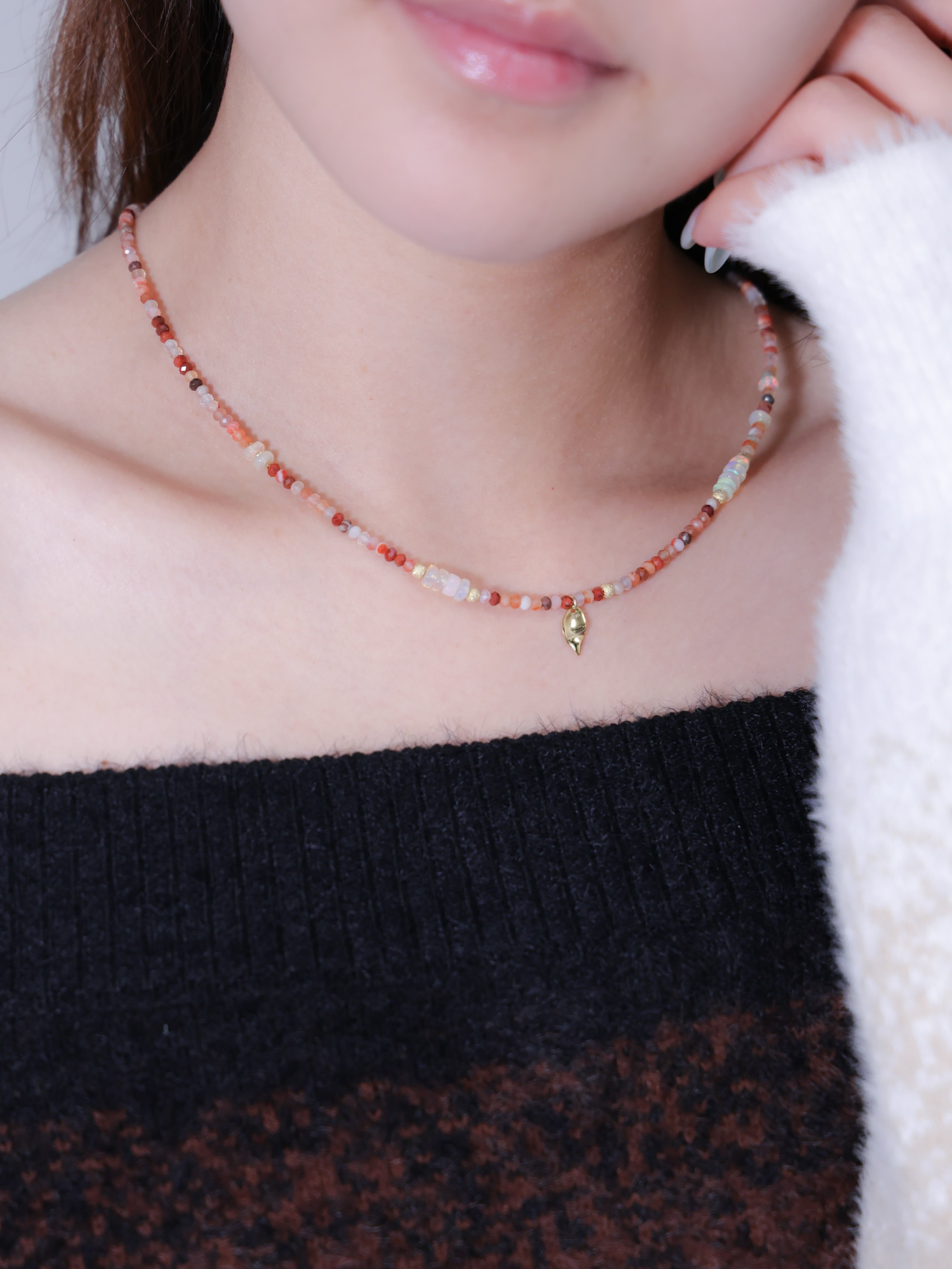 レッドアゲート ネックレス着用 黒ニットコーデ 夕陽のような温かな色彩