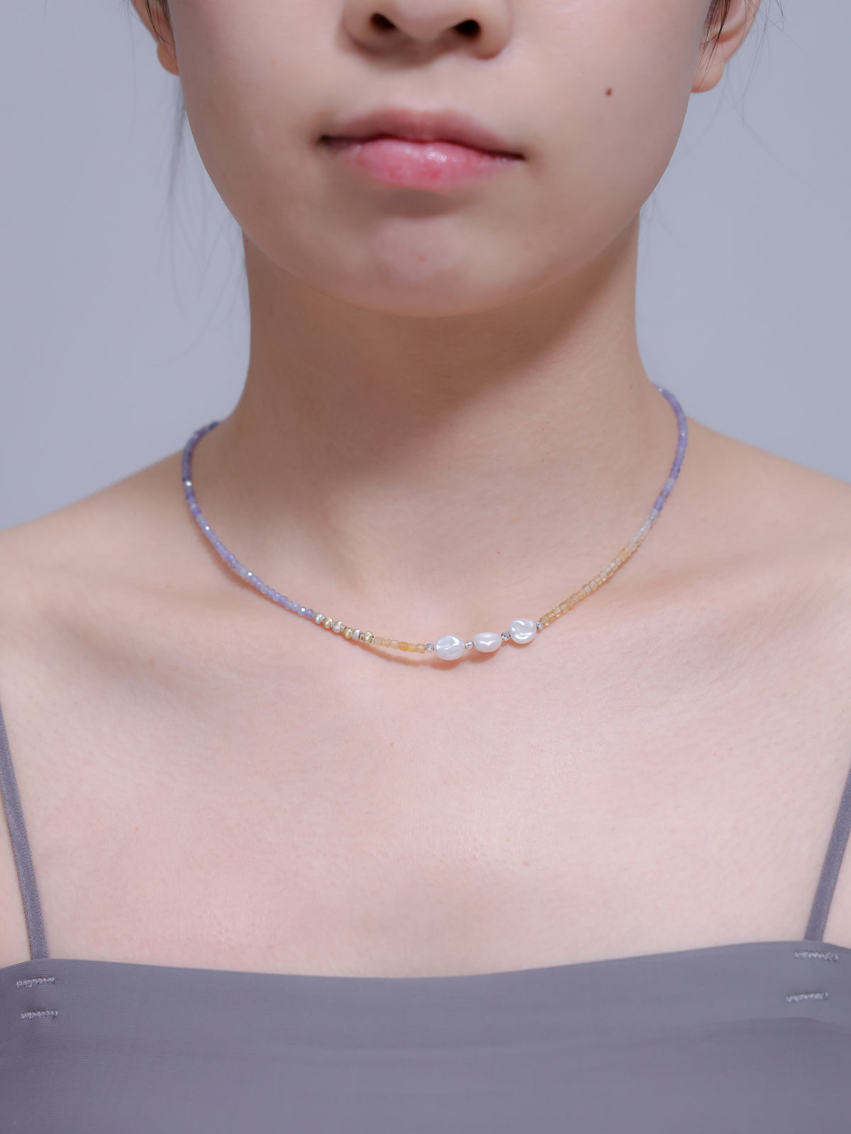 正面からの着用写真。鎖骨ラインを綺麗に見せる華奢なサイズ感と、パールのアクセントが確認できる画像。