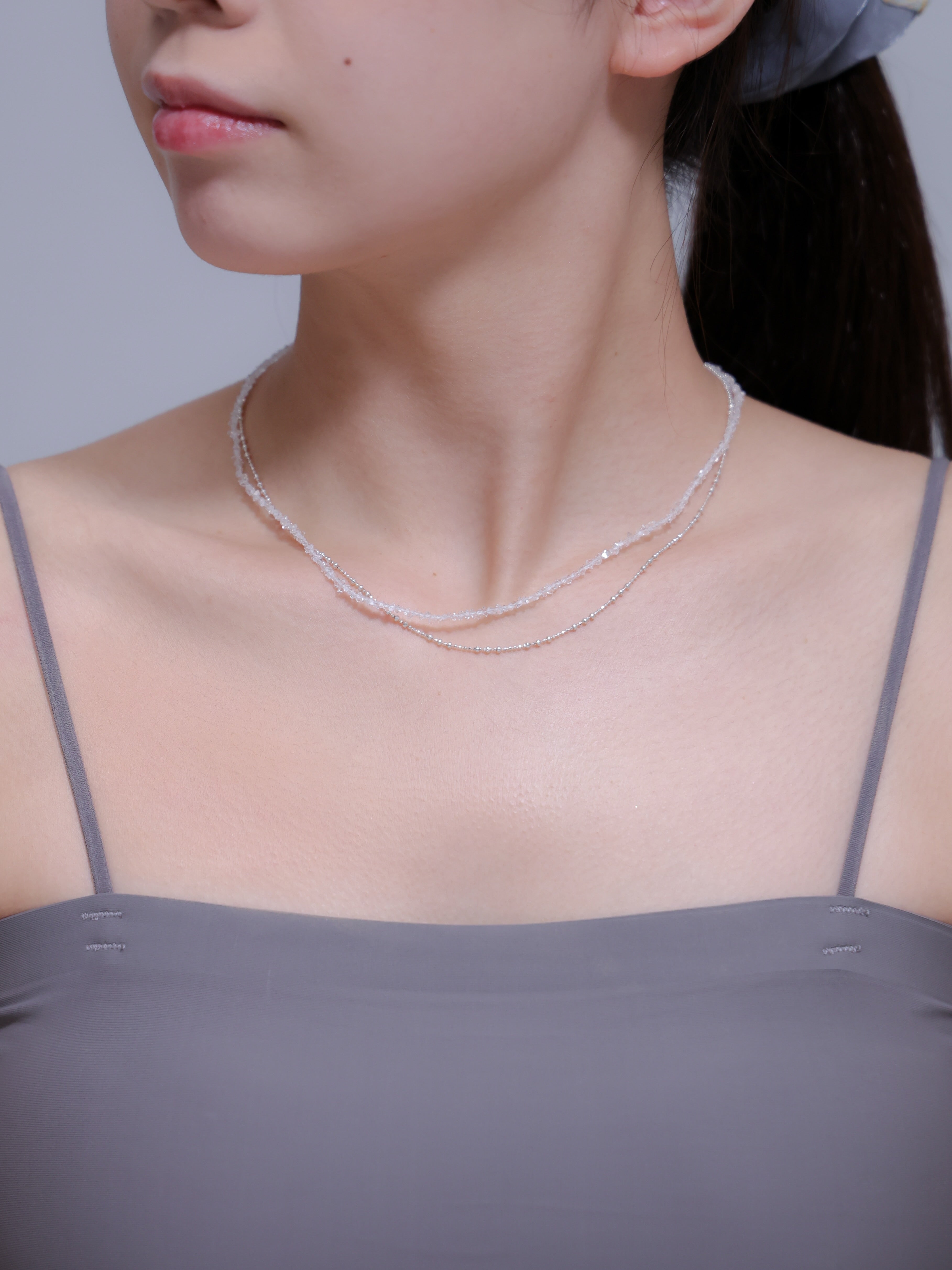 正面からの着用写真。デコルテを華奢に見せる2連チェーンのバランスと、クリアな天然石の清涼感。