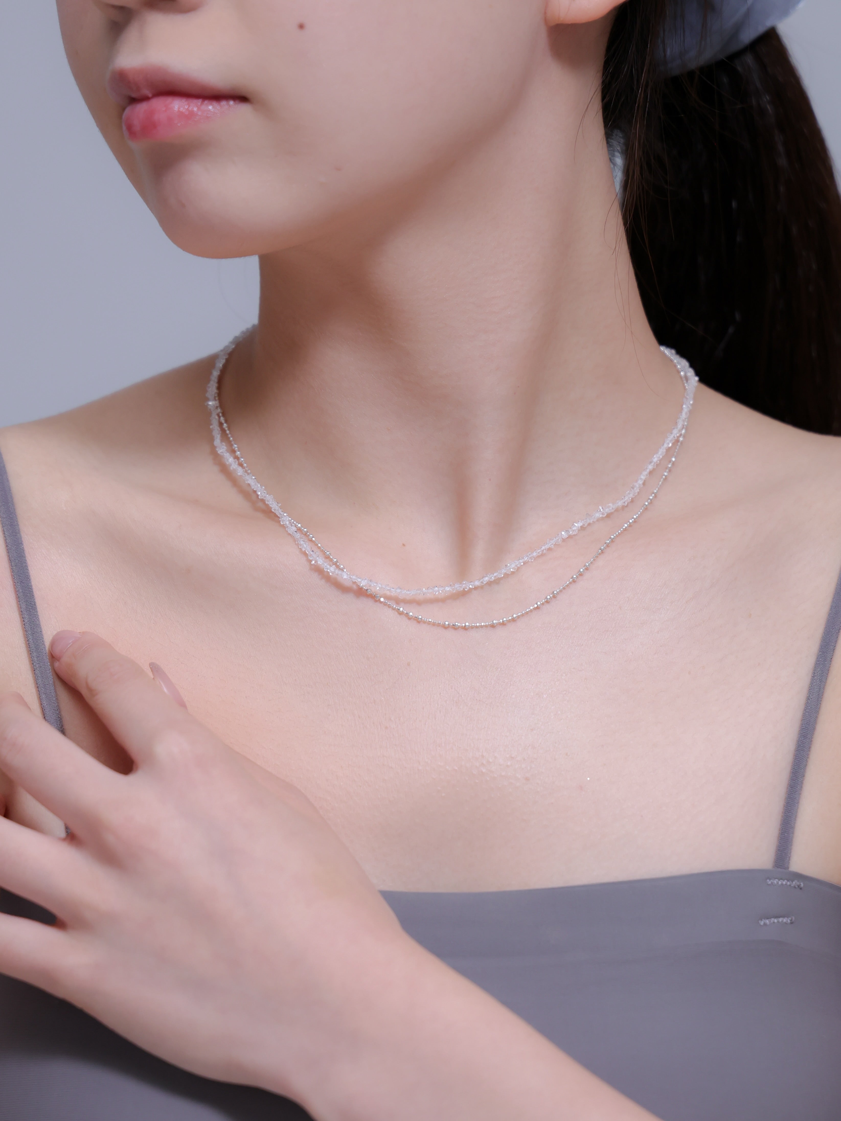 手を添えたモデル着用写真。ヒーリングストーンとしても人気のフェナカイトを、日常的に身につけられるジュエリー。