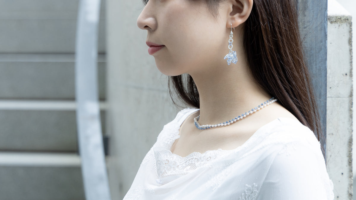 タティングレースのイヤリングとネックレスを身につけた女性の横顔