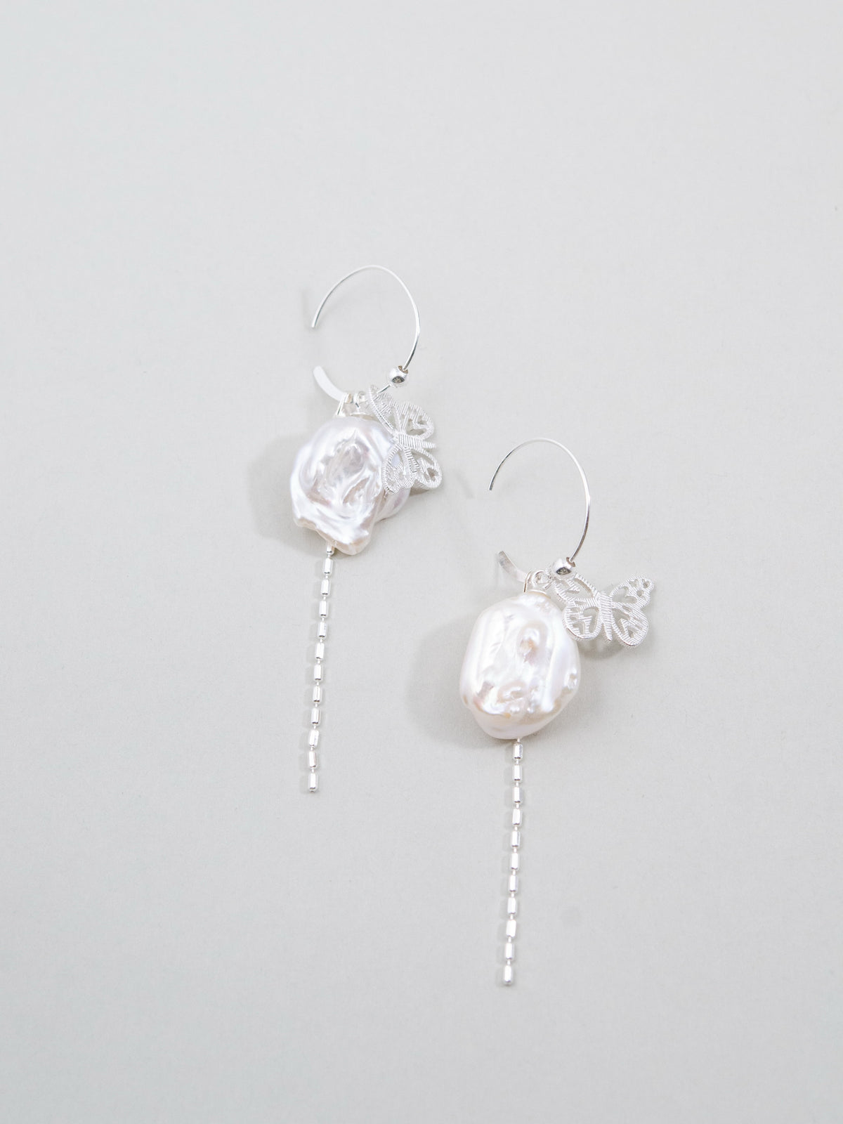 淡水バロックパール & バタフライ フープピアス - 【銀の白蝶】。大粒の変形パールと銀の蝶が舞う、揺れるチェーン付きSV925製耳飾り。