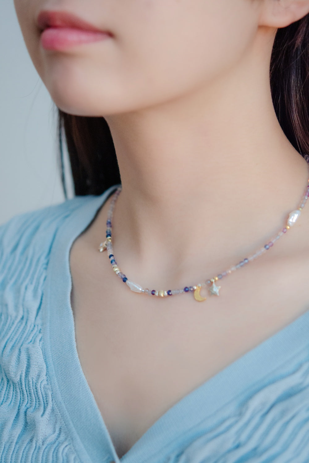 ネックレス着用 斜めアングル 明るい色の服にも合う紫のアクセント