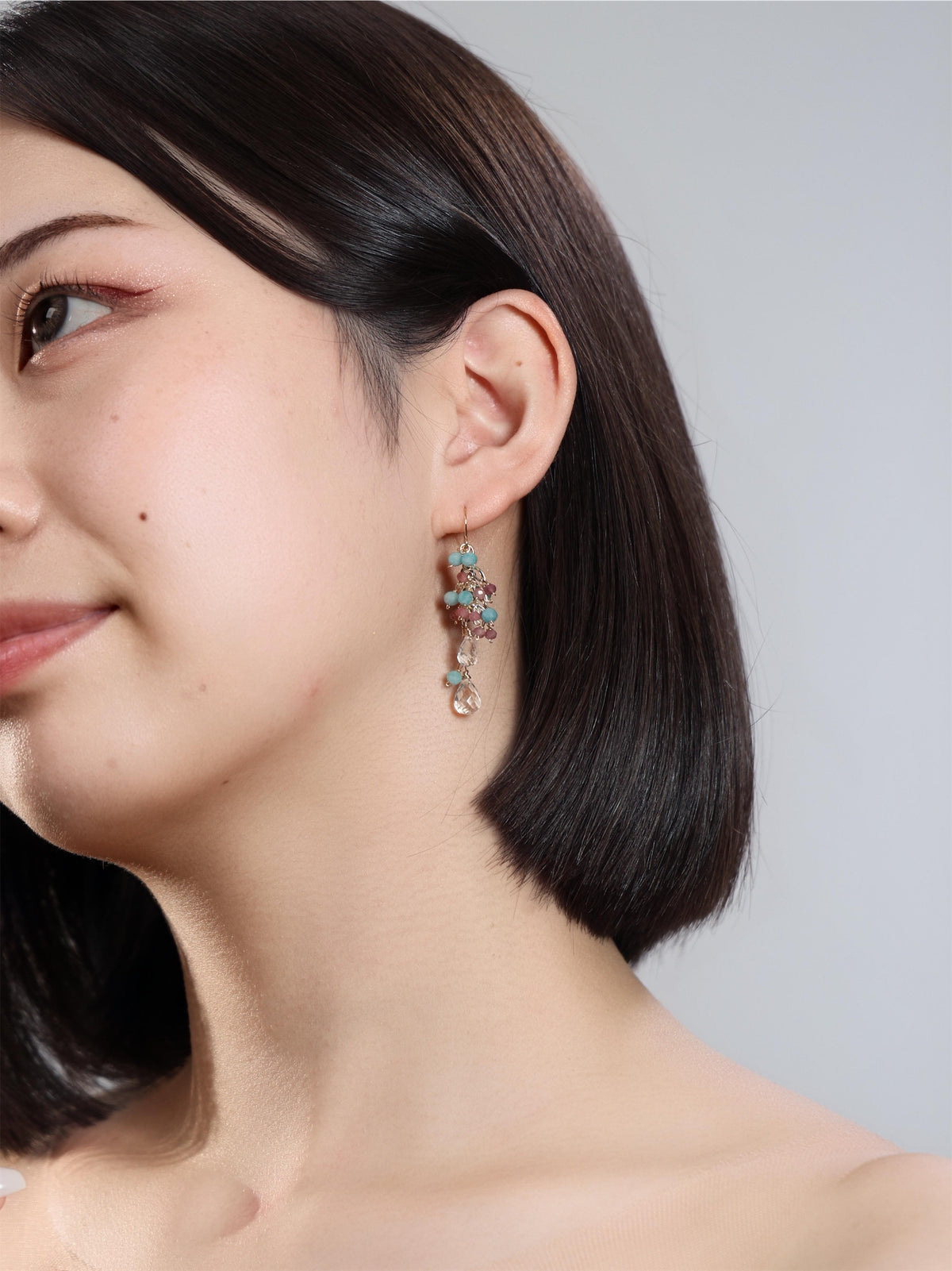 アマゾナイトとピンクトルマリンのロングピアスを着けた横顔