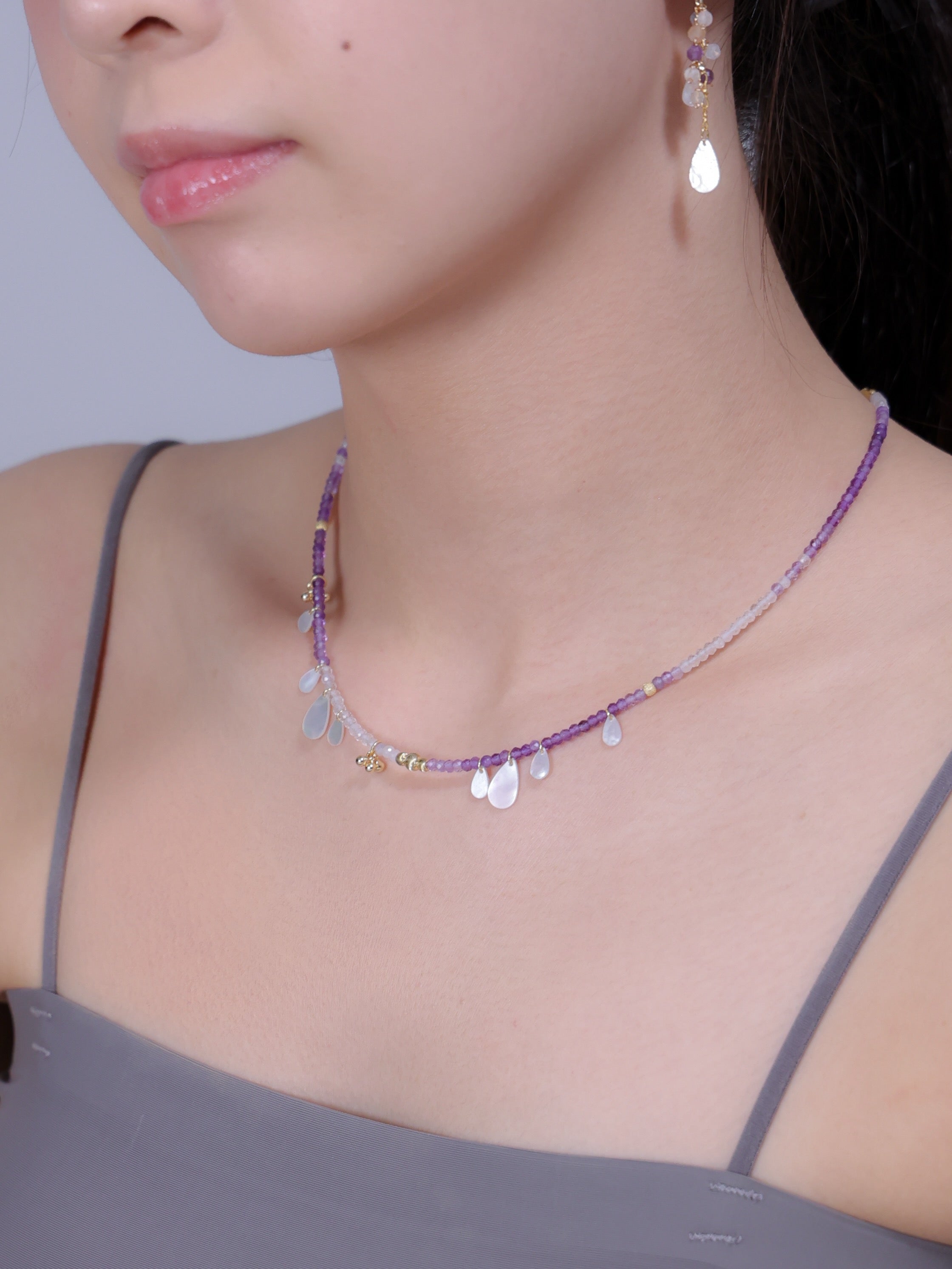 アメジスト ネックレス着用 横顔 グレーのトップスと純白の艶めき