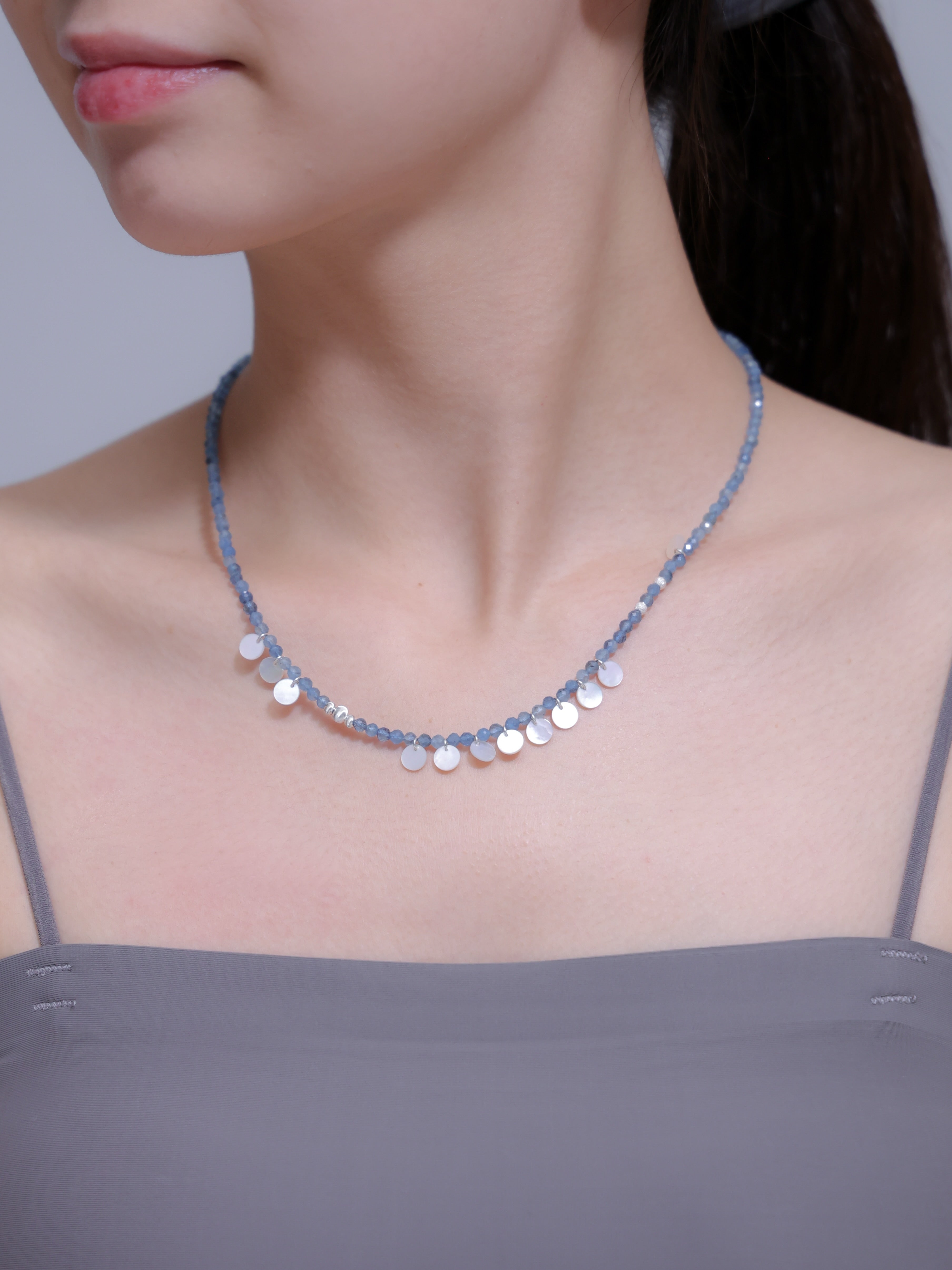 アクアマリン ネックレス着用 横顔 グレーのキャミソールと海の青