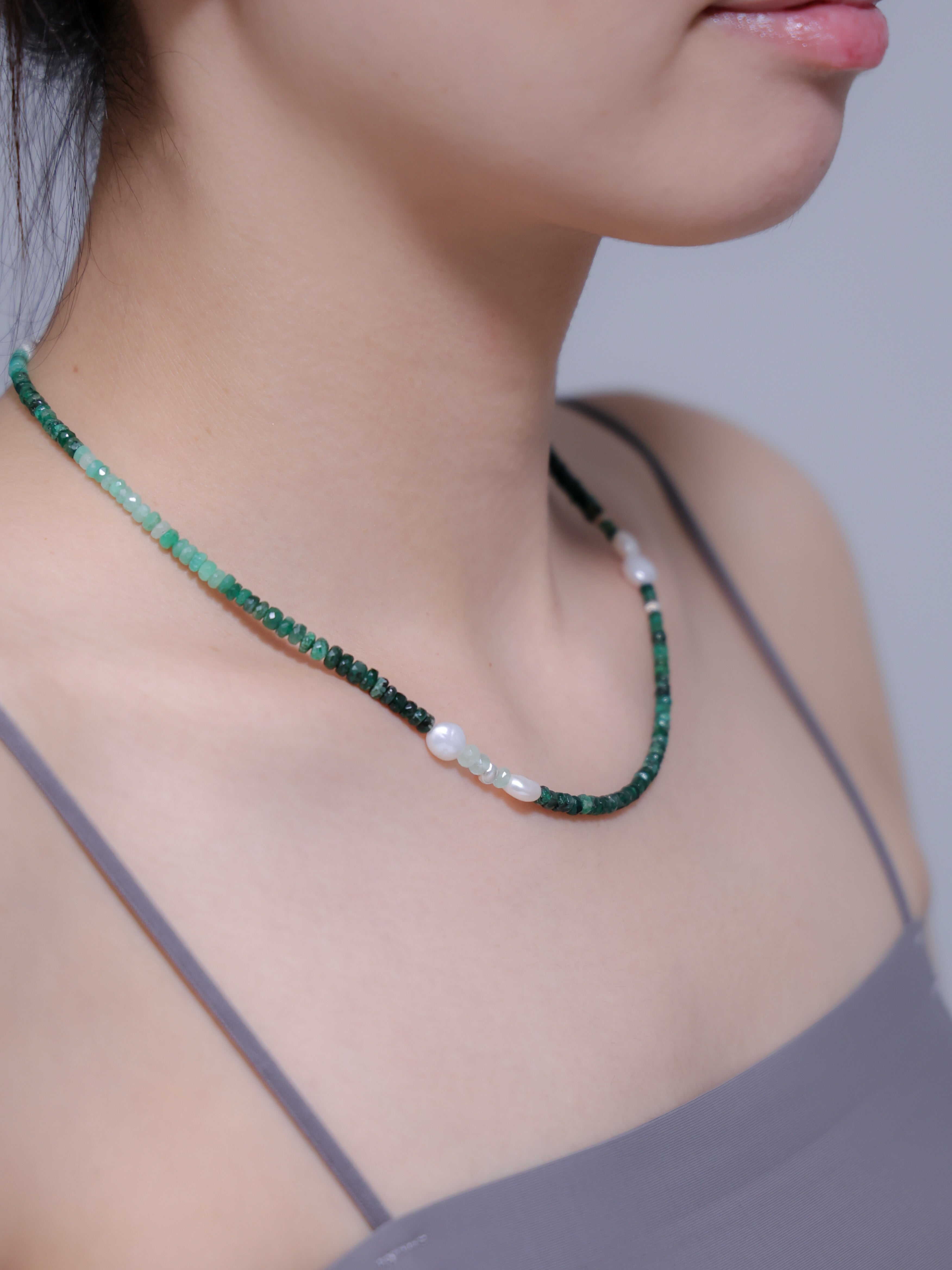 エメラルド ネックレス 着用画像 横顔 グレー トップス 新緑カラー