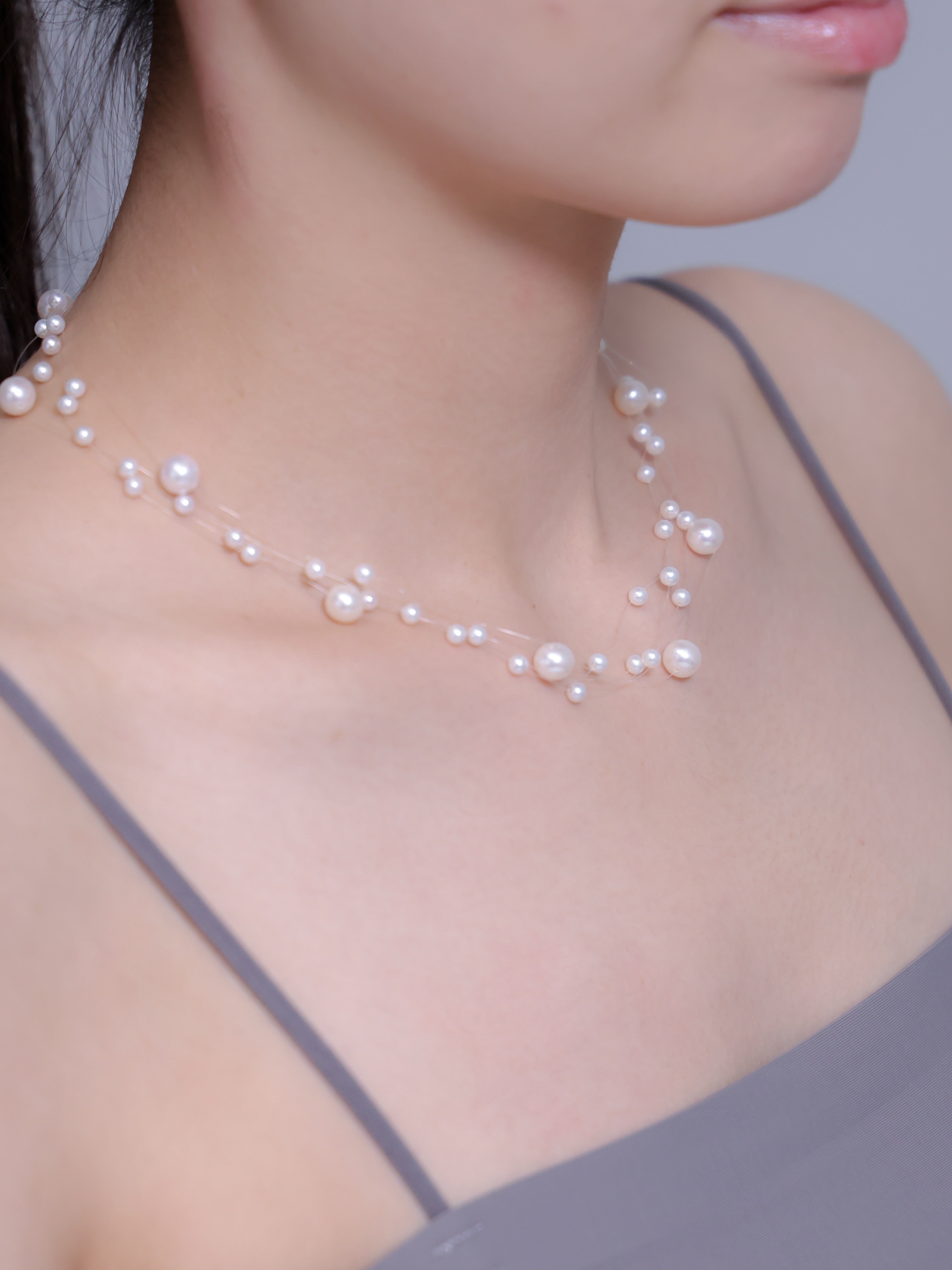 イリュージョンネックレス着用 横顔 首元の淡水パールと透明糸