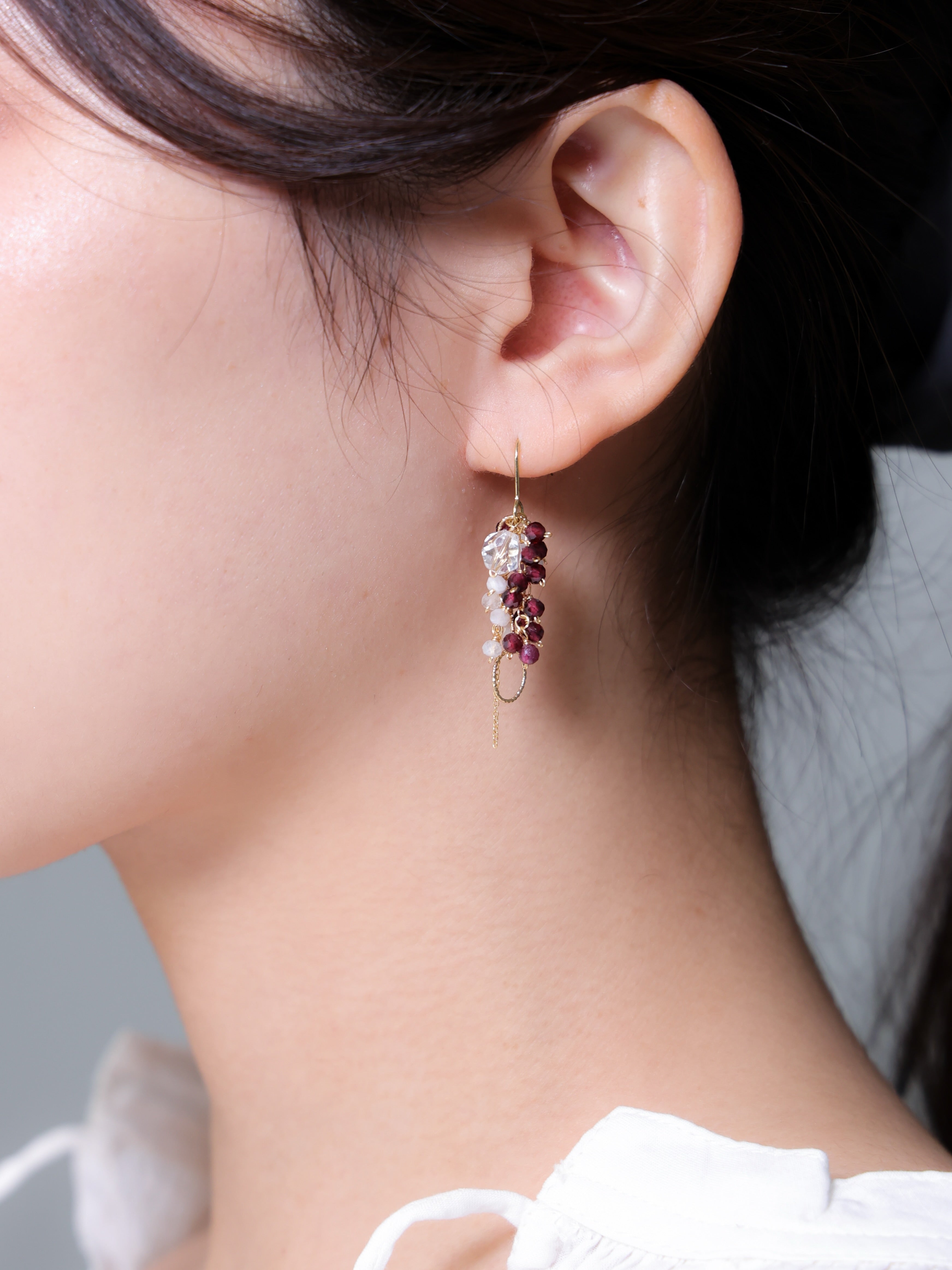 ガーネットとムーンストーンのピアス着用 横顔 白いトップスと深紅のコントラスト