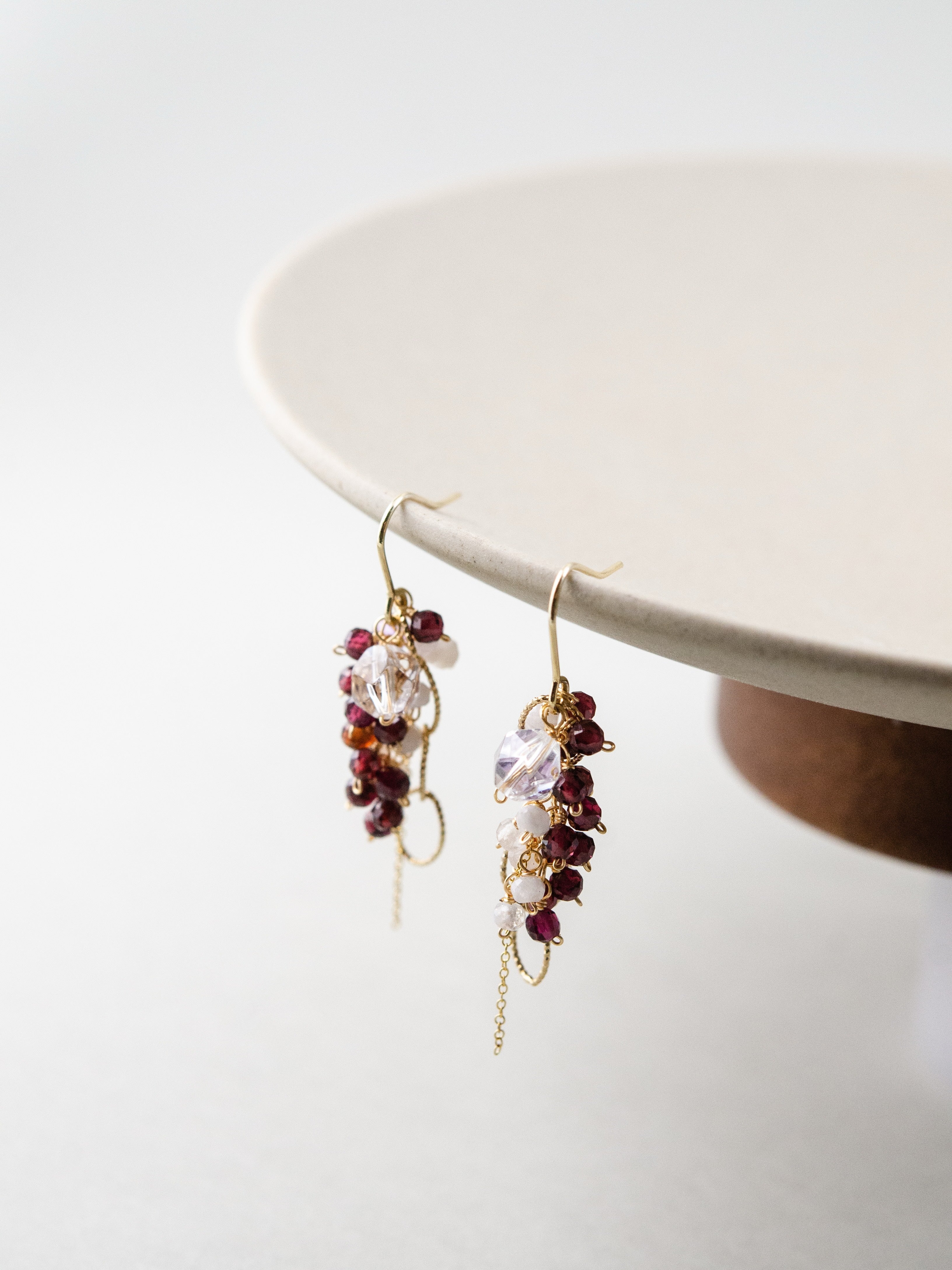 ガーネット & ムーンストーン ピアス 白い皿の縁にディスプレイ 繊細な房状デザイン