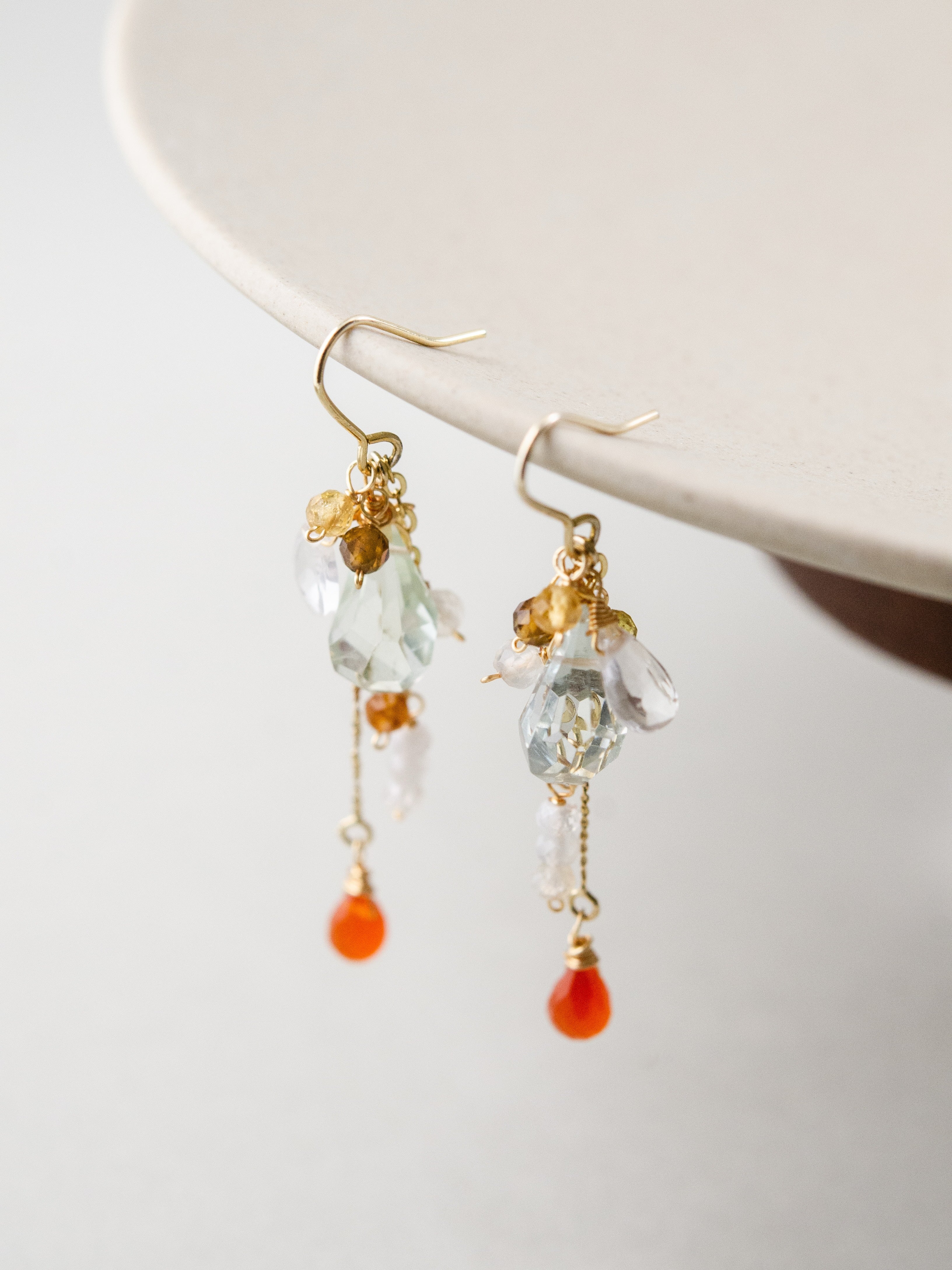 揺れる天然石ピアス 皿の縁にディスプレイ オレンジガーネットのアクセント