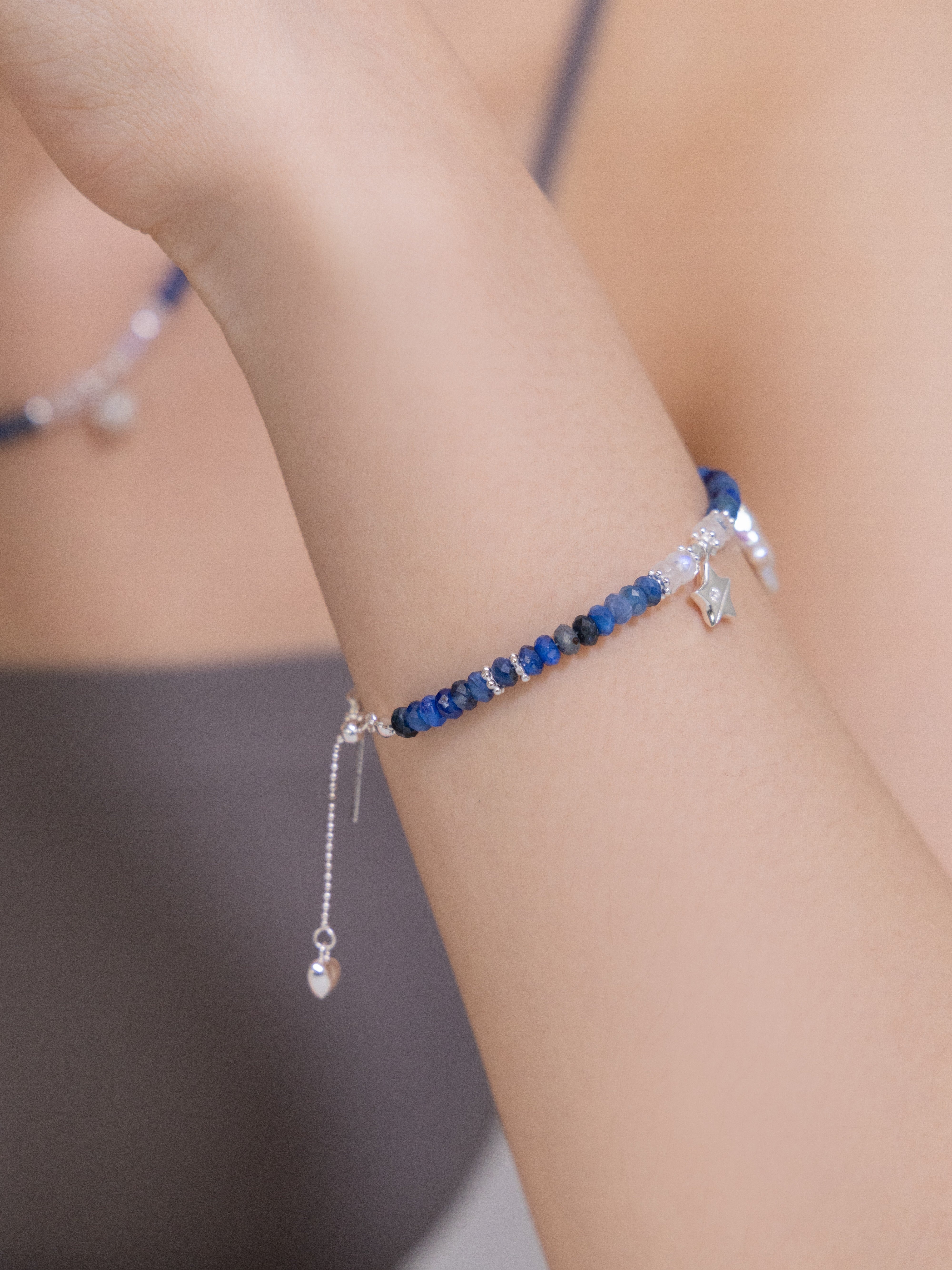 カイヤナイト ブレスレット着用 手首 星と月のチャームが揺れる深碧の青