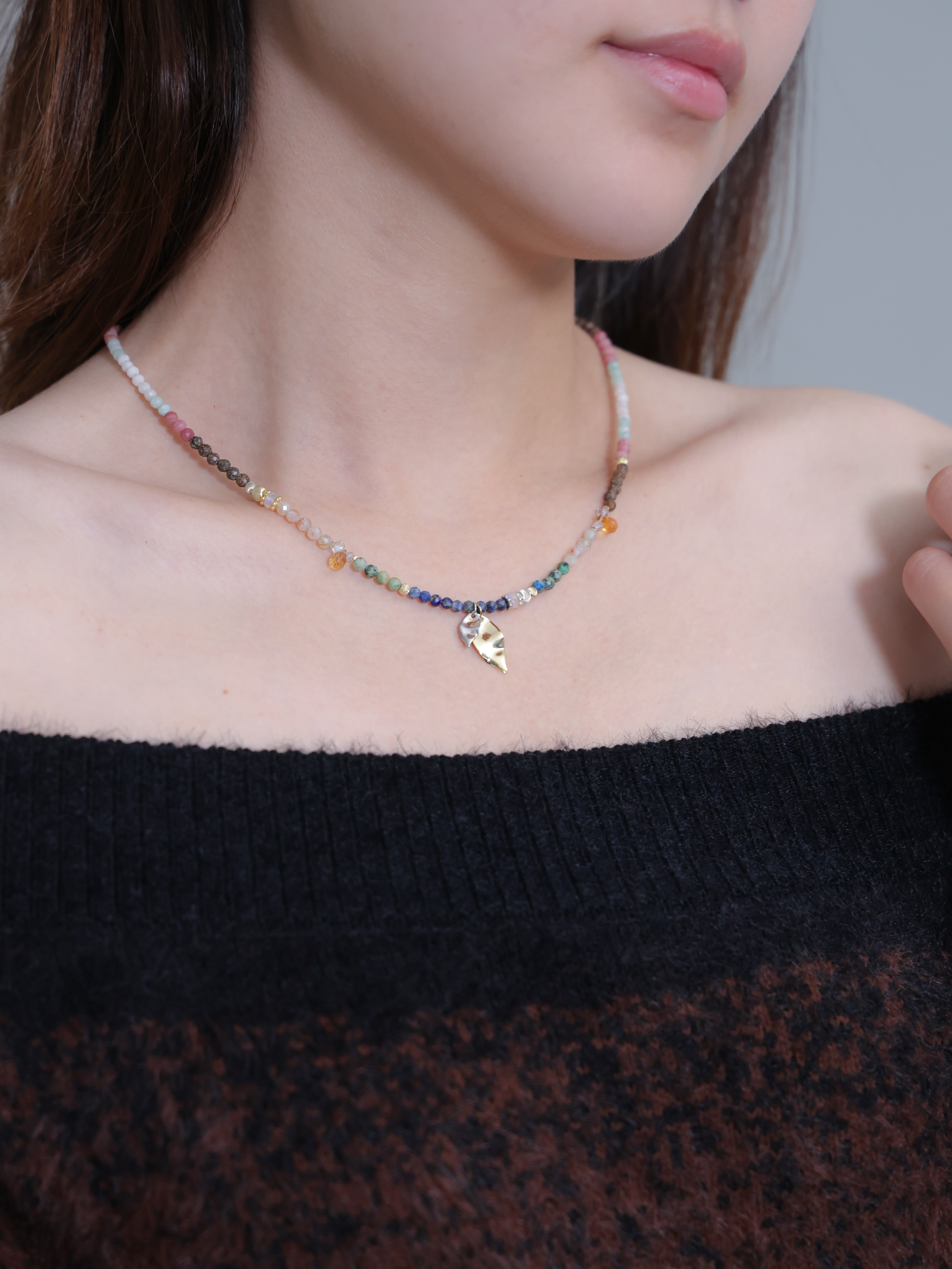 ネックレス着用 上品な黒トップスとマルチカラーのアクセント