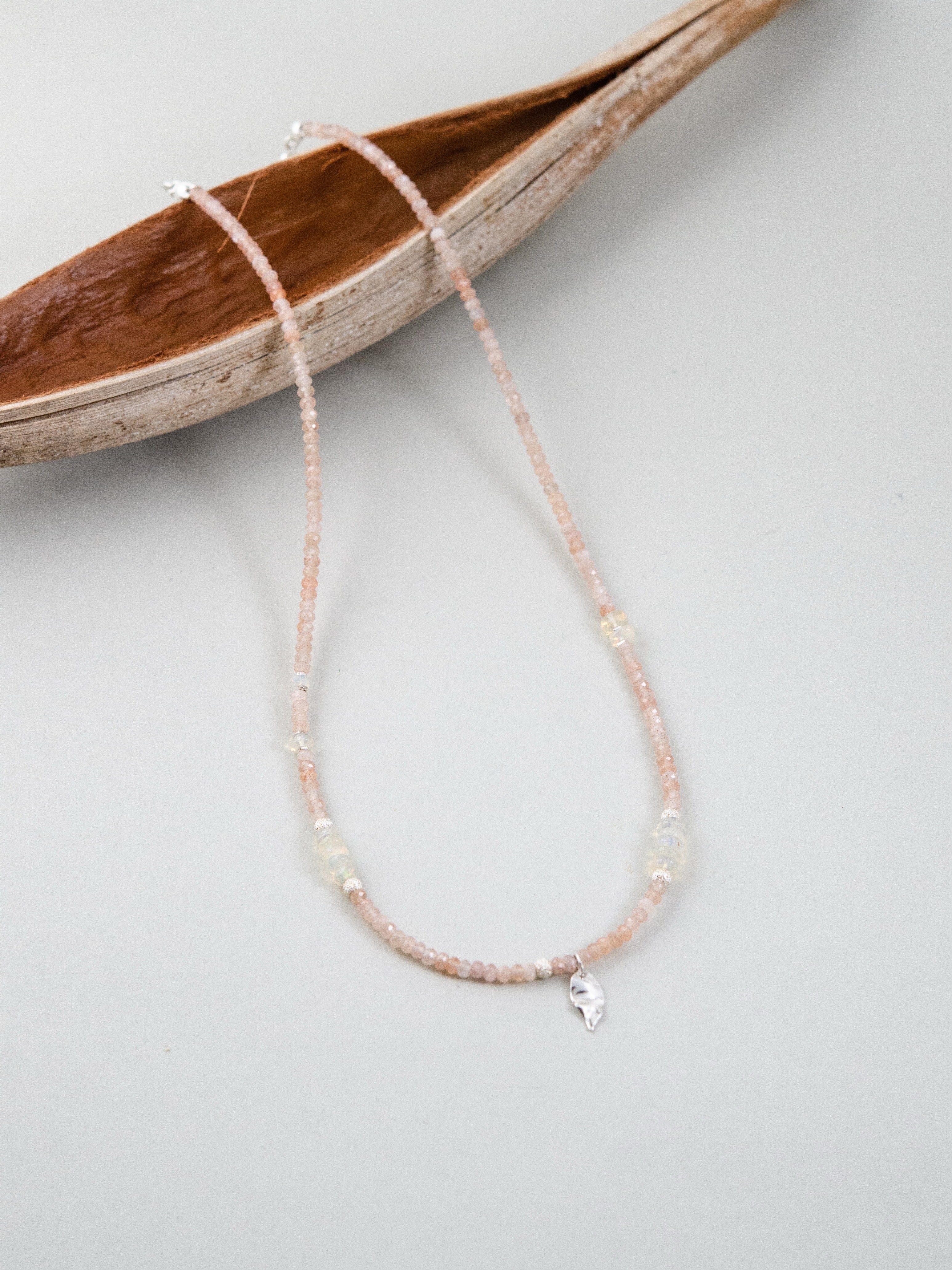 ネックレス スタイリング 木製トレイと陽だまりのイメージ