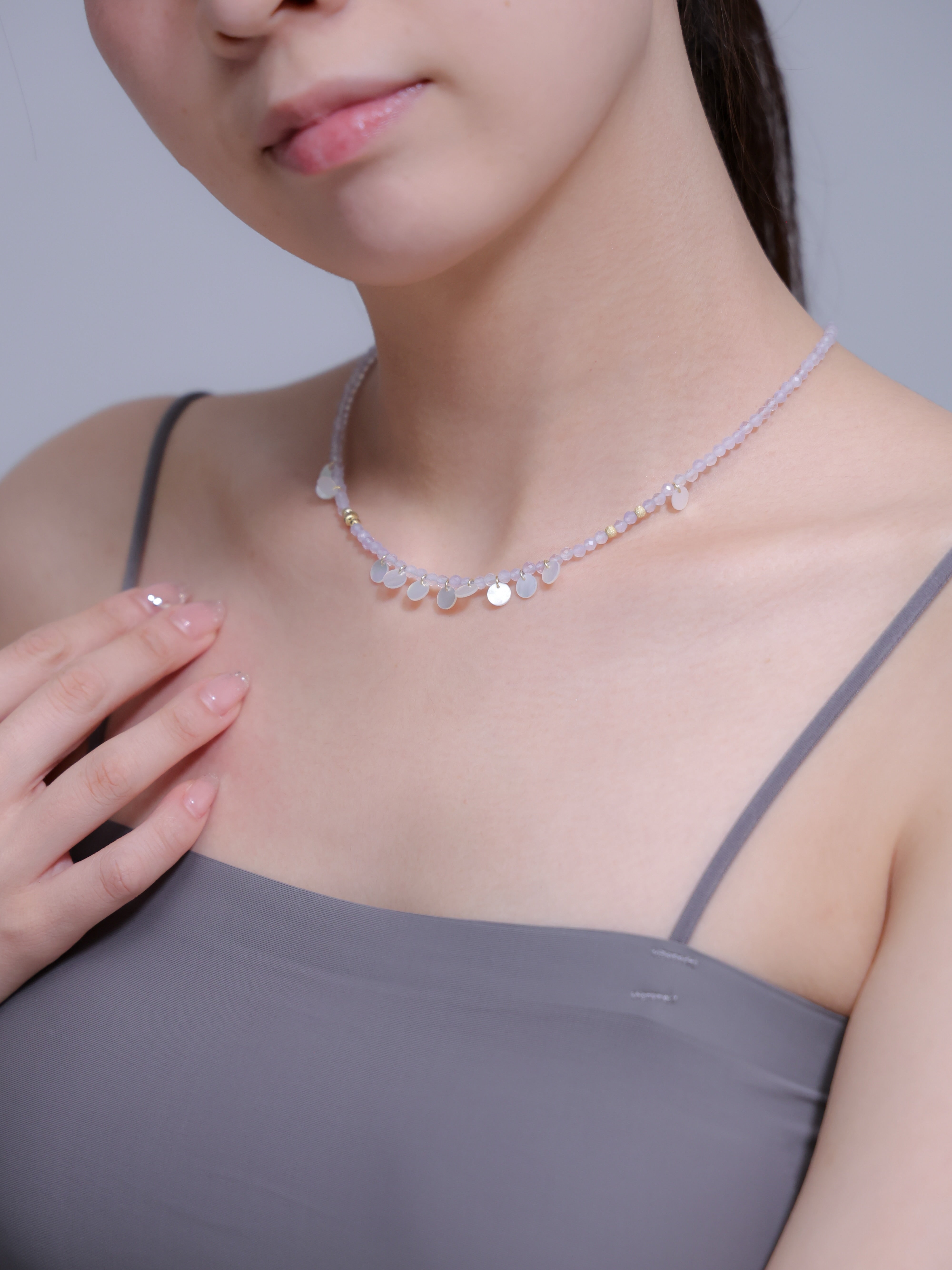 パープルカルセドニー ネックレス着用 胸元に手を添えた上品なポーズ