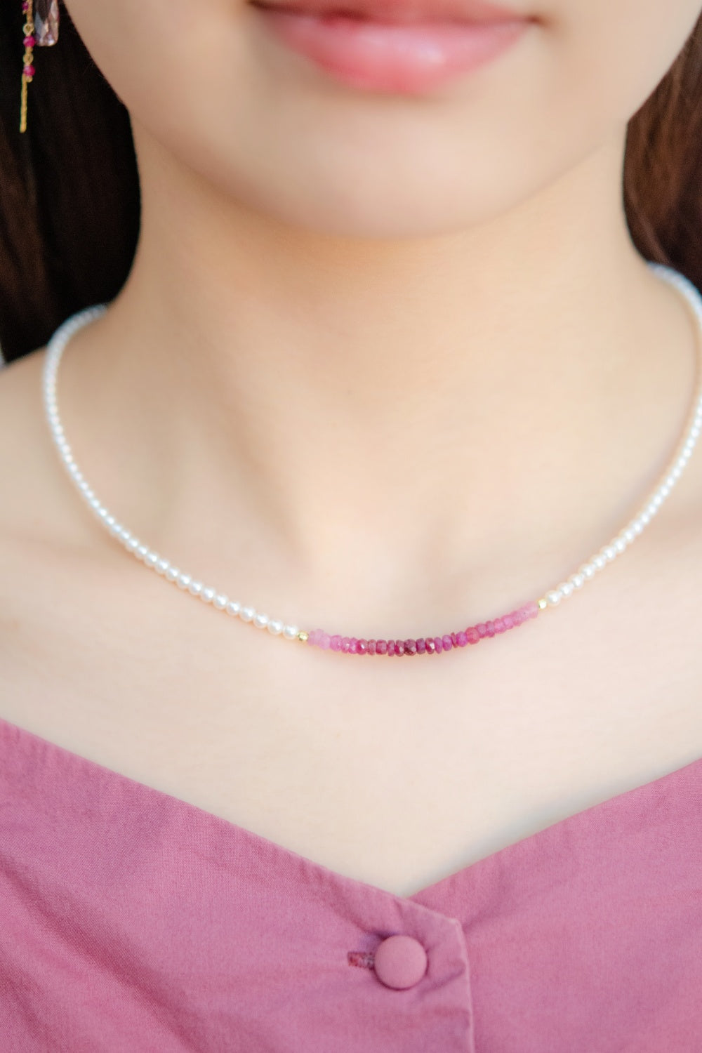 ルビー ネックレス着用 ピンクのトップスと赤いグラデーション 7月誕生石