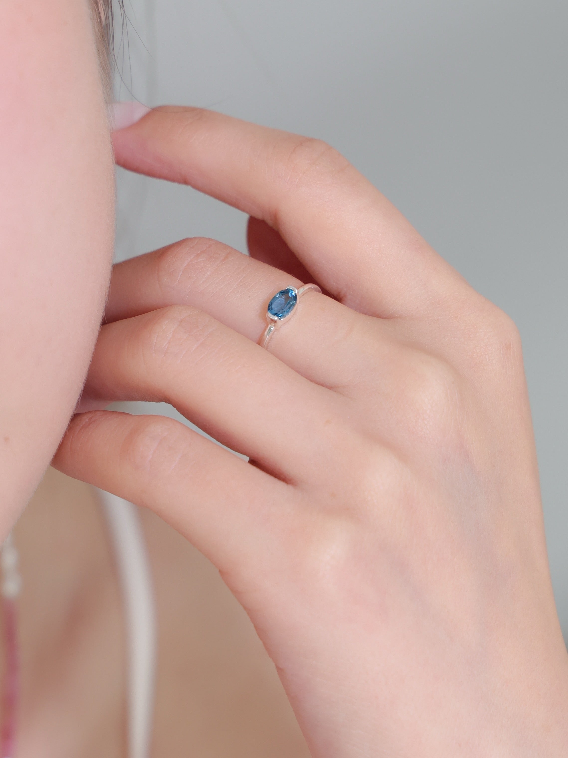 青い天然石 ブルートパーズリング着用 横顔に添える手