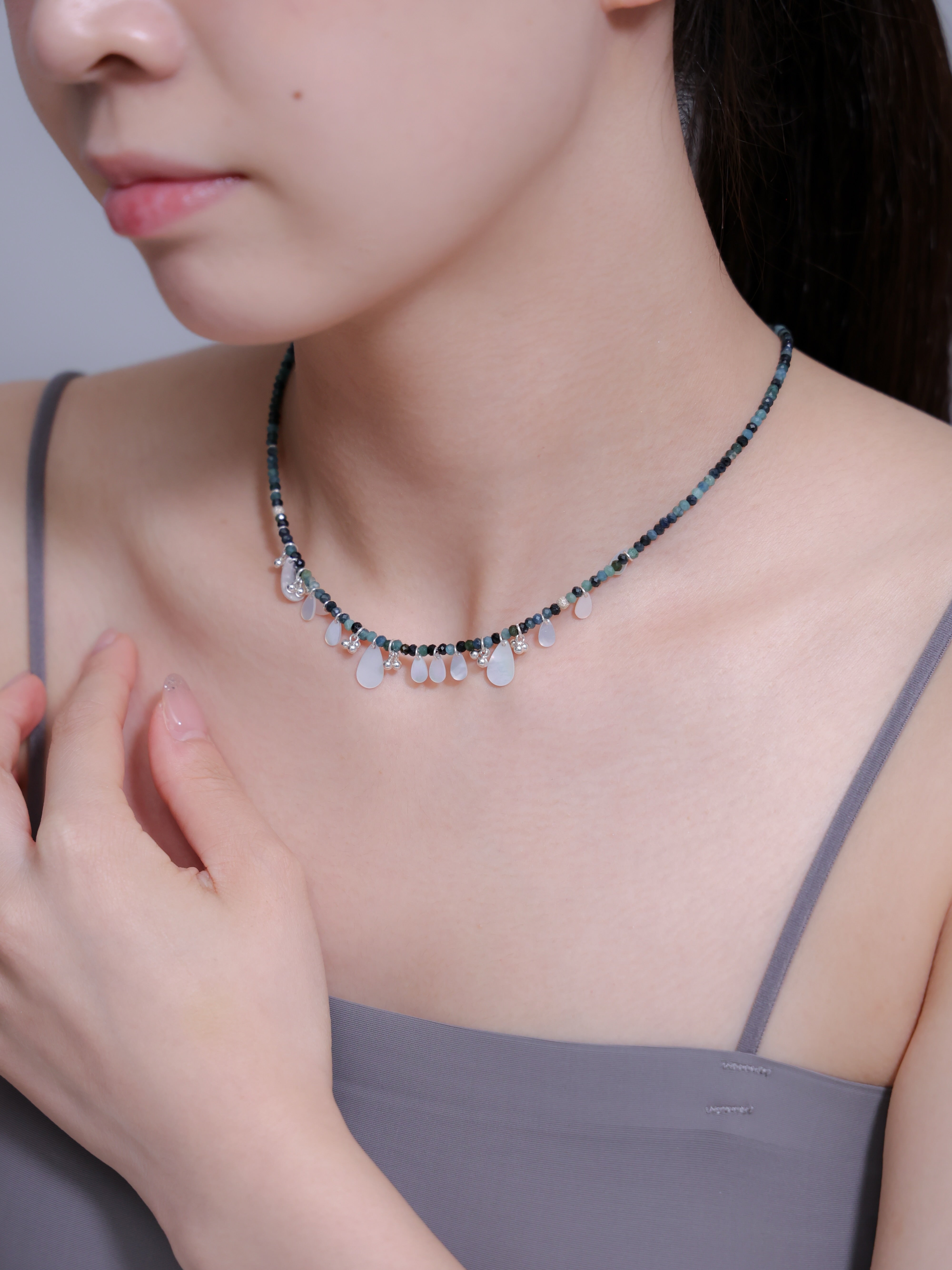 トルマリンネックレス着用 手を添えるポーズ 揺れる白蝶貝